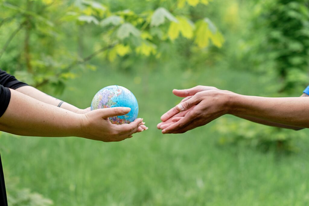 Areas Two hands exchanging a small globe symbolizing global unity and ecology awareness.